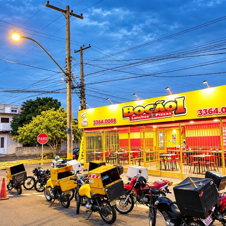 Fachada do Bocão 1 ao entardecer, com as motos de entrega na porta, na Av. Minas Gerais, Sarandi